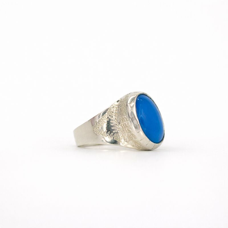 Silver ring with a blue stone on a white background