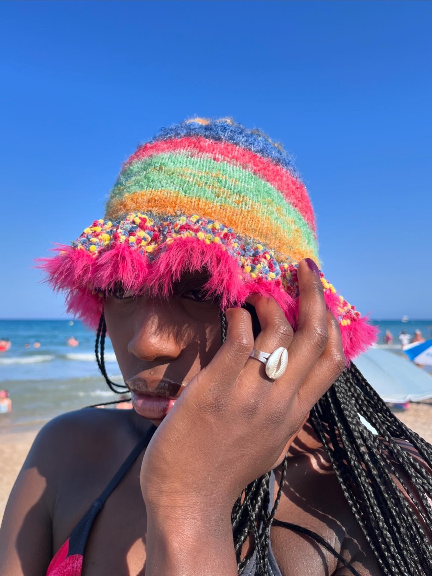 Person wearing a colorful striped hat on a beach