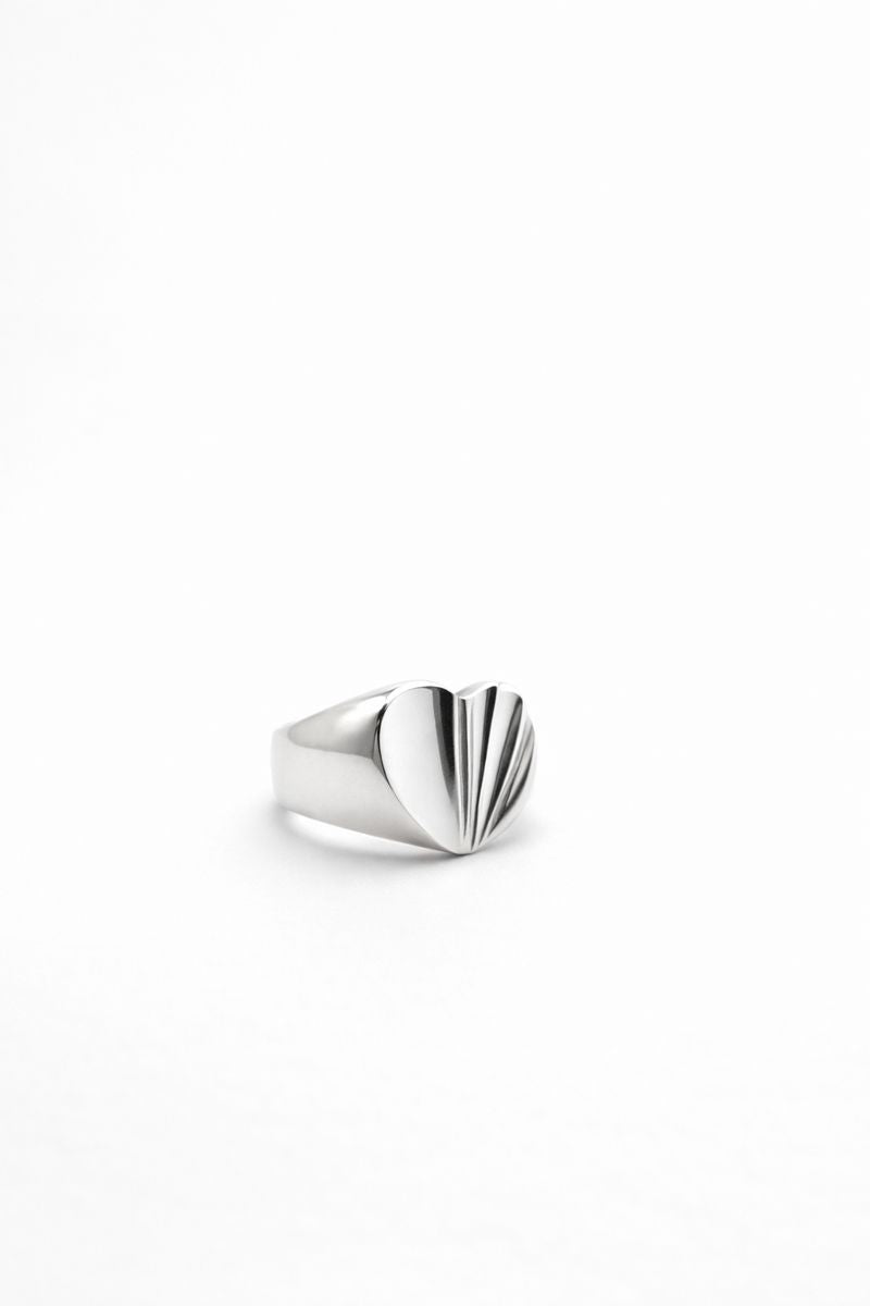 Sterling silver split heart ring with one polished side and one textured side on white background