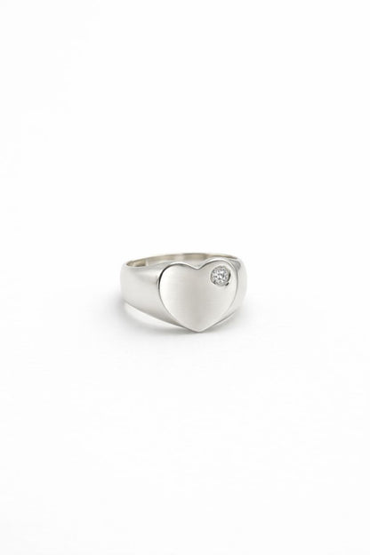 Sterling silver heart ring with small stone detail set on a clean white background