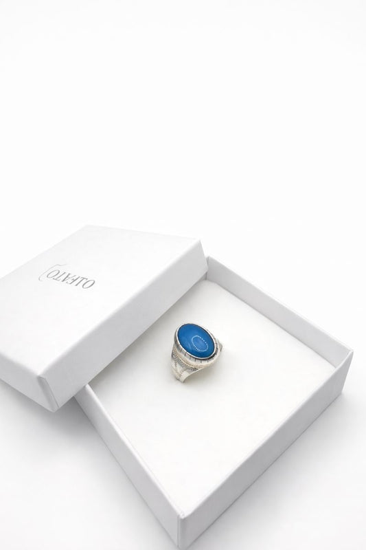 Silver ring with a blue stone in a white yafato box on a white background