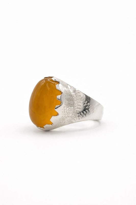 Silver ring with a large amber stone on a white background