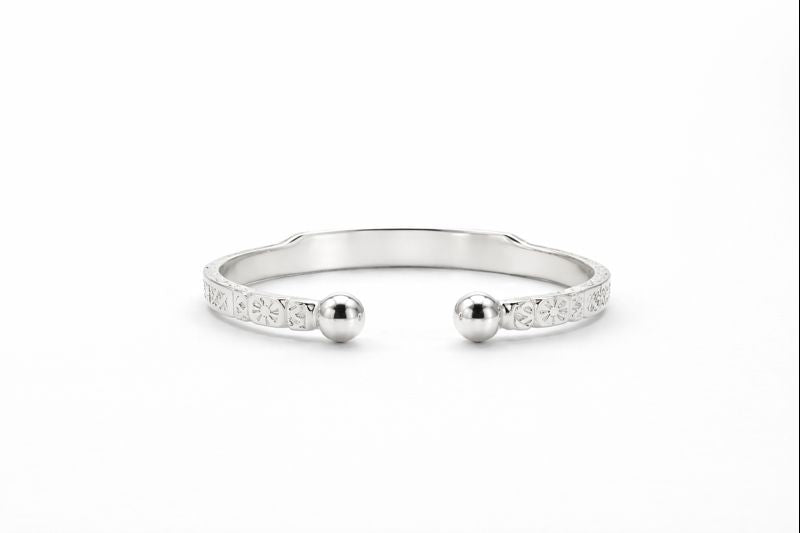 Silver bracelet with two spherical charms on a white background